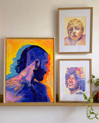 Framed gay and queer art featuring men, with colorful portraits of Marsha P. Johnson and Lady Gaga.