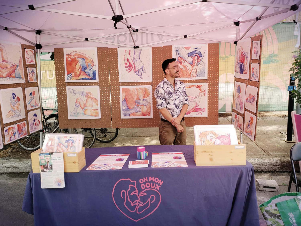 Sylvain at his Oh Mon Doux market booth surrounded by his prints